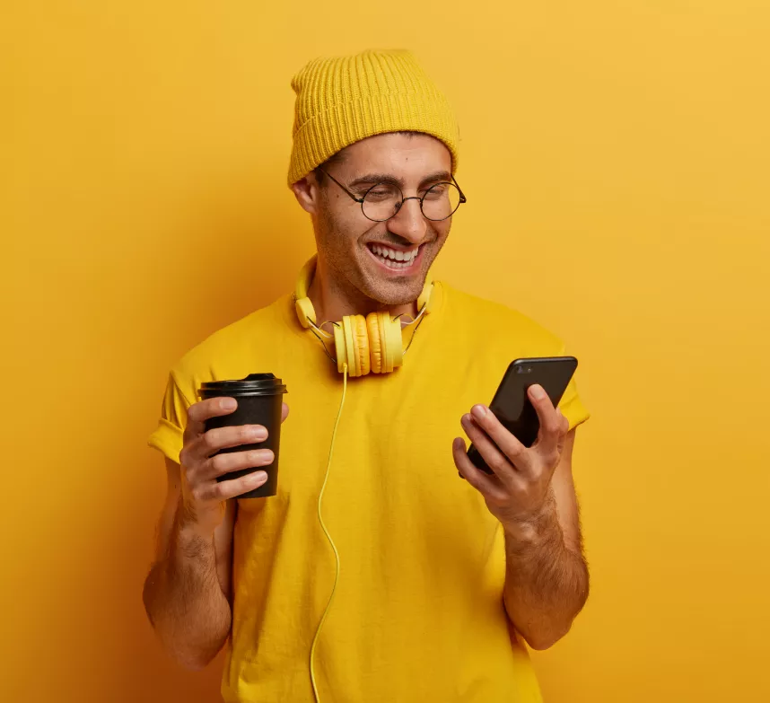Man holding a coffee cup and his phone
